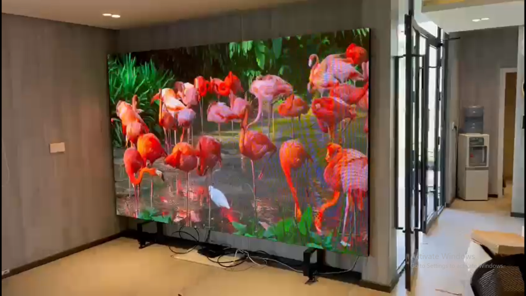 Image of a indoor screen with a bright colored display presenting a scenary of fishes.